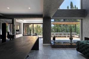 a kitchen and living room with a large glass wall at La Fortuna Villa - Award Winning Luxury Villa Close to Corfu Town in Corfu Town