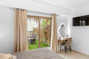 a bedroom with a bed and a desk and a window at The Azure Suites in Haraki