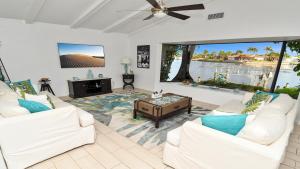 Una sala de estar con dos sofás blancos y una mesa. en Amazing - 4 Bed Billiard Table luxury canal pool, en Cabo Coral