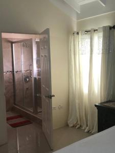 a bathroom with a shower and a glass door at Royal Palm Luxury Villas in Ocho Rios
