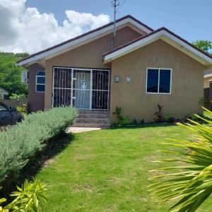 a house with a gate and a yard at Royal Palm Luxury Villas in Ocho Rios