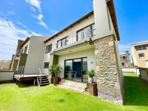 a house with a green lawn in front of it at Family Beach House Retreat in Swakopmund