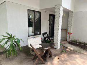 a room with a chair and a table and a window at Sunset Serenity Cove in Ko Phangan