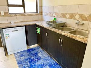 a kitchen with a sink and a dishwasher at Family Beach House Retreat in Swakopmund +16 photos