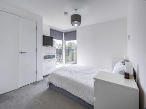 a white bedroom with a bed and a window at Glasgow Riverside - Private Homestay in Glasgow