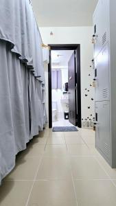 a bathroom with a tiled floor and a corridor at Mari Condo Hostel in Manila