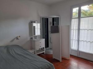 a bedroom with a bed and a sink and a refrigerator at Jolie appartement lumineux de 8 couchages in Porquerolles