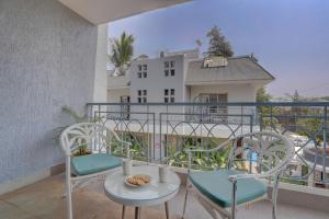 a balcony with chairs and a table and a building at Alaya Stays Adarsh Elegant 3-BHK Villa With Private Pool in Lonavala