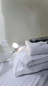a stack of white pillows sitting on top of a bed at Mari Condo Hostel in Manila