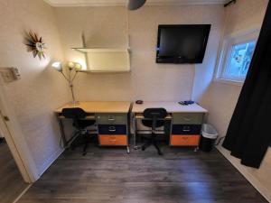 Zimmer mit einem Schreibtisch mit 2 Stühlen und einem TV in der Unterkunft Suites On Chocolate - The Annville Cottage in Annville