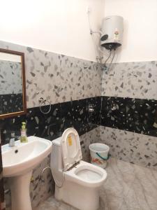 a bathroom with a toilet and a sink at Nileshwar Home Stay in Bāgeshwar