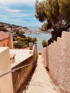 a stone wall with a view of the ocean at Appartement T2 avec Piscine 300m plage et crique in Le Pradet