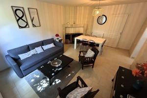 salon z niebieską kanapą i stołem w obiekcie Manoir de la Frazelière - Gîte au cœur des châteaux de la Loire w mieście Joué-lés-Tours