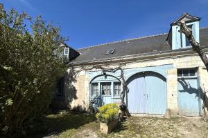 ceglany dom z garażem z niebieskimi drzwiami w obiekcie Manoir de la Frazelière - Gîte au cœur des châteaux de la Loire w mieście Joué-lés-Tours