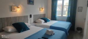 a hotel room with two beds and a window at Hôtel Le petit billot in Vitré