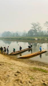 um grupo de pessoas em um barco longo em um rio em BhupuSainik Guest House - Sauraha, Chitwan em Sauraha