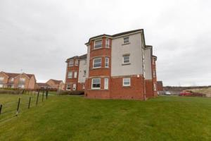 a large brick building in a field of grass at Super Prime Park View Duloch By Tba in Dunfermline