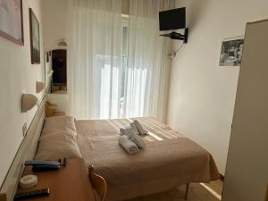 a bedroom with a bed with two towels on it at Hotel Alcazar in Rimini