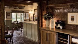 a restaurant with a counter with a vase of flowers at The Bat and Ball in Cuddesdon