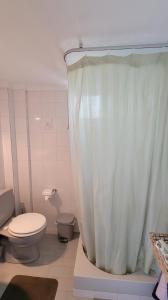 a bathroom with a toilet and a shower curtain at POTIDAIA BEACH HOUSE in Nea Potidaea +32 photos