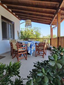 a patio with a table and chairs on a deck at POTIDAIA BEACH HOUSE in Nea Potidaea