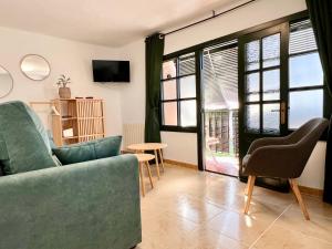a living room with a couch and a table and windows at La Casuca de Orejo - Monabri in Orejo
