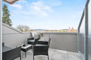 a patio with chairs and a table on a balcony at Modernes Landhaus am Bodensee in Ravensburg