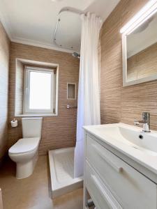 a bathroom with a toilet and a sink and a window at La Casuca de Orejo - Monabri in Orejo +39 photos