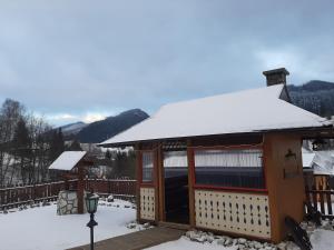 a small building with snow on the roof at Penzión Stodola in Ždiar