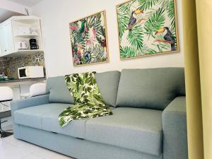 a living room with a blue couch with a pillow at PLAYMAR TROPICAL in Maspalomas