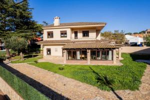 a house with a large yard in front of it at Costabravasuites Villa Los Vientos in Calella de Palafrugell