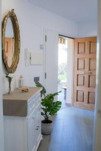 a kitchen with a mirror and a door with a plant at Costabravasuites Villa Los Vientos in Calella de Palafrugell