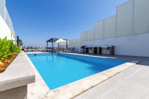 a large swimming pool next to a building at Pool and Sea Views 3BR and Assistant's Room Villa with Beach Access and BBQ Facilities, Sharm - Al Dana Villa, Al Dana Island by Deluxe Holiday Homes in Fujairah