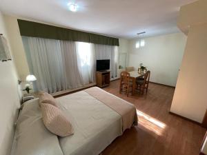 a bedroom with a bed and a table with a dining room at San lorenzo apart in Mendoza