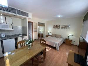 a room with a bed and a table and a kitchen at San lorenzo apart in Mendoza