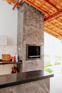 a stone fireplace in a kitchen with a counter top at Chácara Recanto Lunar in Boituva