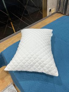 a white pillow sitting on top of a bed at Люкс квартира возле Керуен сити in Aktobe