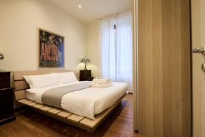a bedroom with a large bed with white sheets at Emme Loft I First Moon - Exclusive Design Apartment with balcony in Milan