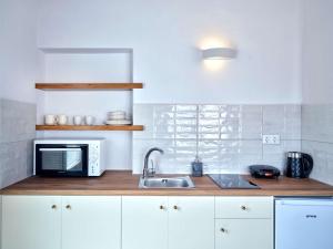 a kitchen with a sink and a microwave at Lefkes Starlight Studio in Lefkes