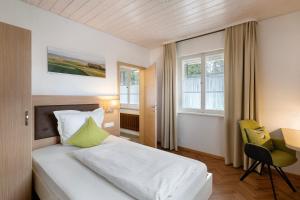 a bedroom with a bed and a desk and window at Pension Waldliesel in Dornstetten
