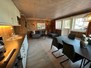 a kitchen and living room with a table and chairs at Fagernes Camping in Fagernes