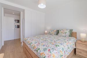 a bedroom with a large bed with a floral bedspread at Don Tenorio Chic Apartment in Lagos +16 photos