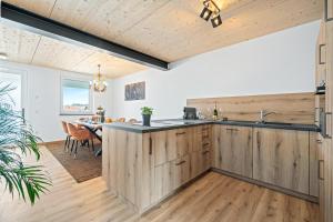 an open kitchen with wooden cabinets and a dining room at Jungle Feeling am Bodensee in Ravensburg +11 photos