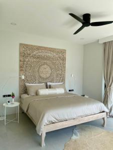 a bedroom with a large bed with a ceiling fan at Villa Miss Elephant in Ban Thung +47 photos