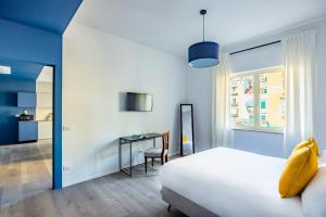 a bedroom with a bed and a desk and a window at Street Stritt'60 by Wonderful Italy in Naples