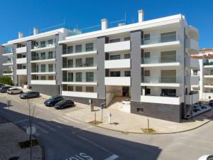 an apartment building with cars parked in a parking lot at Don Tenorio Chic Apartment in Lagos