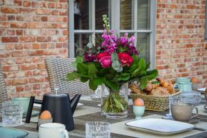 a vase of flowers sitting on a table with eggs at Haus Goed Libben in Archsum