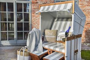 a patio chair with an awning on a porch at Haus Goed Libben in Archsum