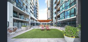 einen Innenhof in einem Gebäude mit Bänken und Stühlen in der Unterkunft CBD Resort with King Suite, Pool, Gym, Sauna, Cafe, Wifi, IGA in Adelaide + 24 Fotos