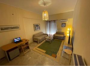 アテネにあるAristofanis 3bdr 4th floor Apartment in Pagratiのリビングルーム(ソファ、ノートパソコン付きテーブル付)